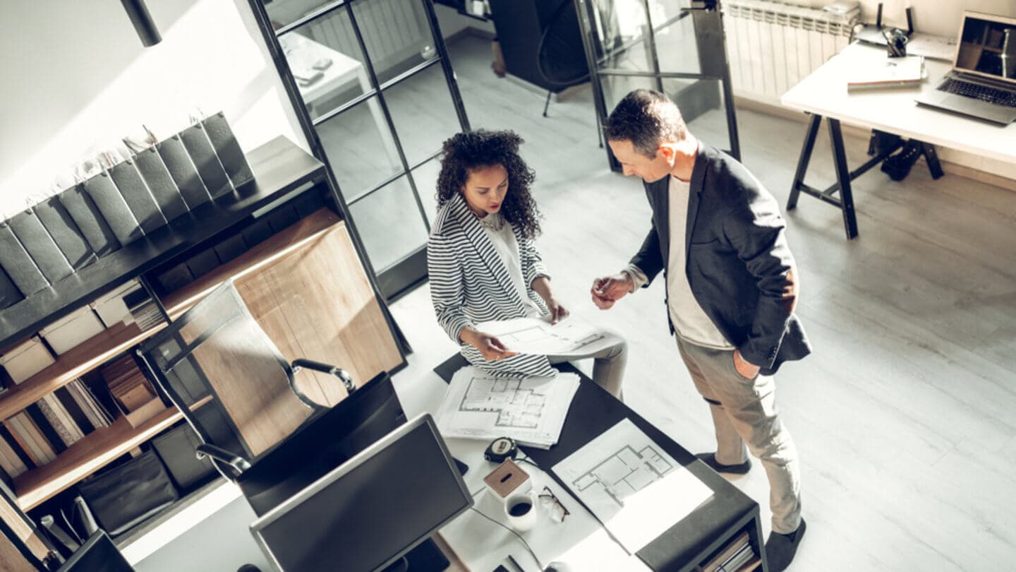 Colleagues discussing building plans in a private office envrionment