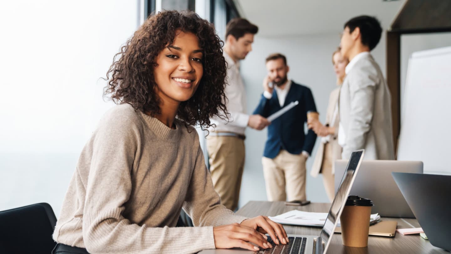 A young business woman and her colleagues inside a private working space