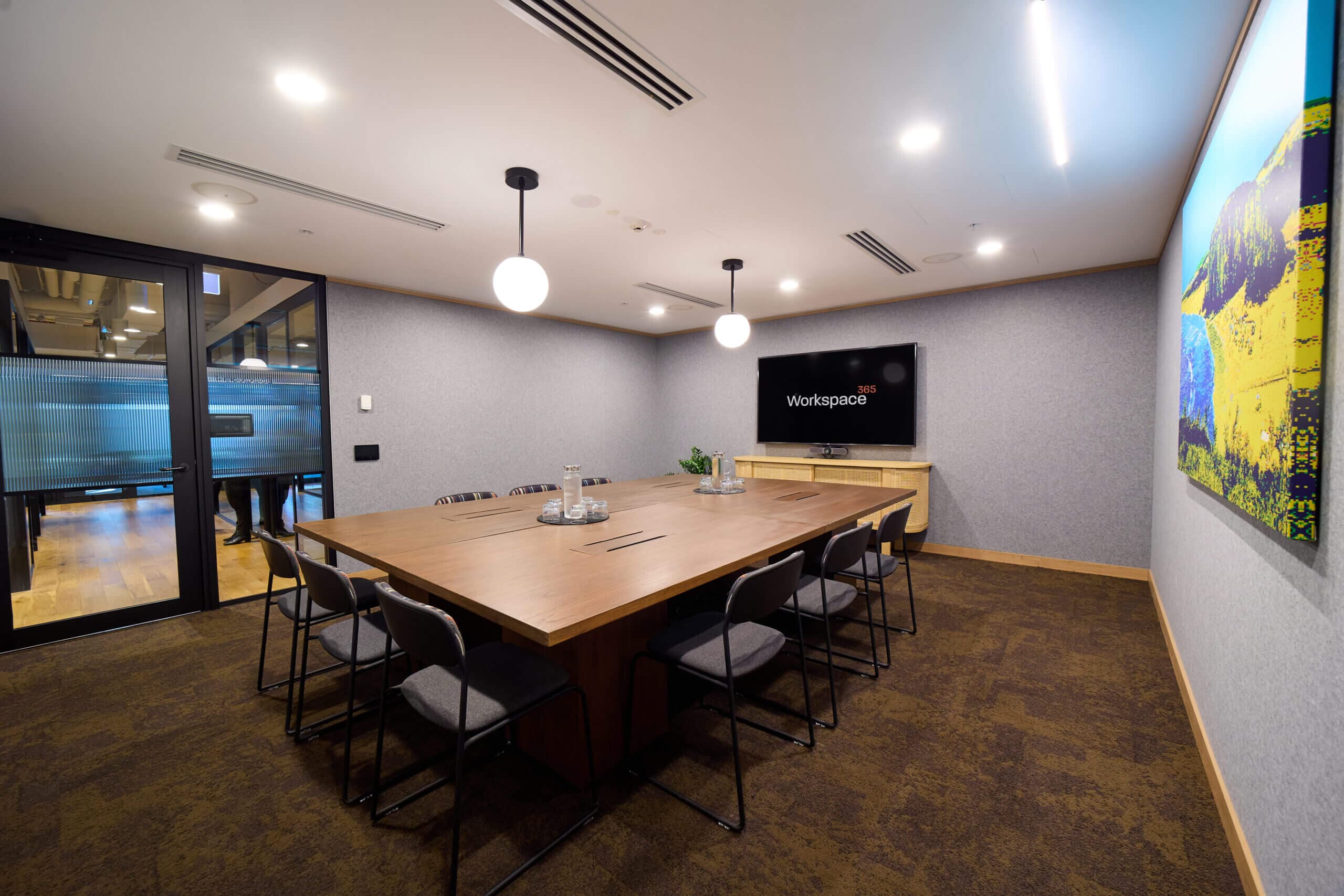 Conference room with large table, chairs, and display screen.