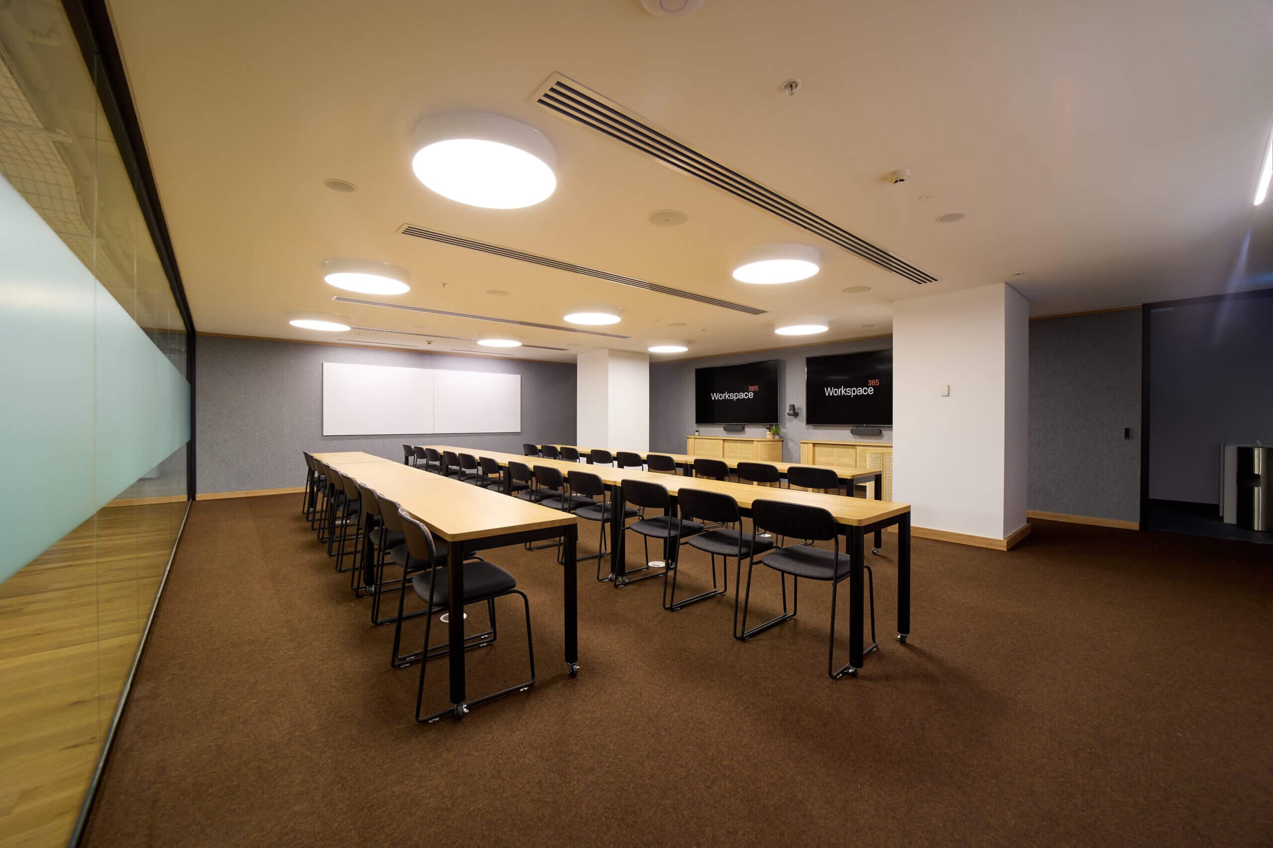 Meeting room with tables and chairs set for a presentation or conference.