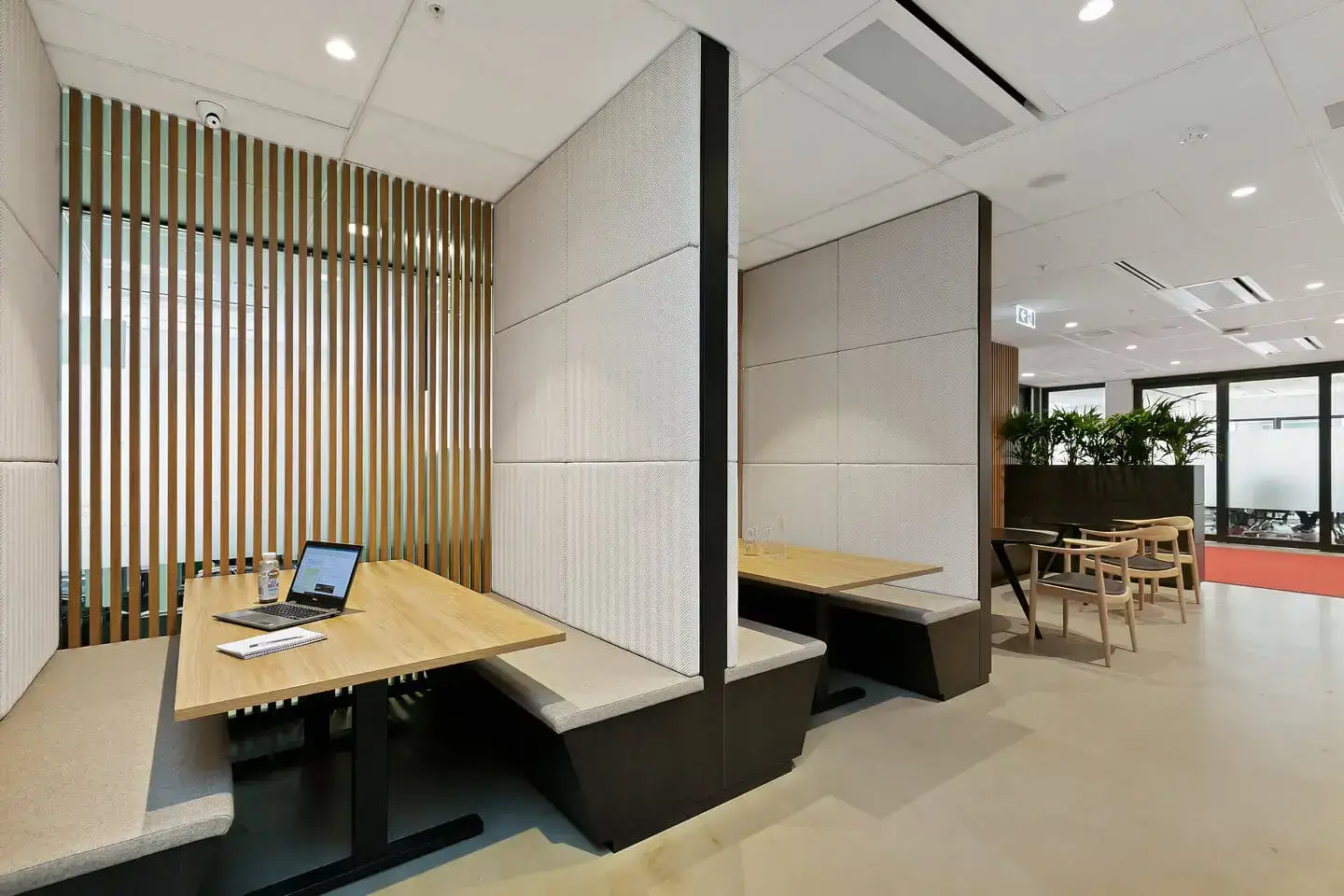Flexible office with modern desk, chairs, and floor-to-ceiling windows overlooking the city